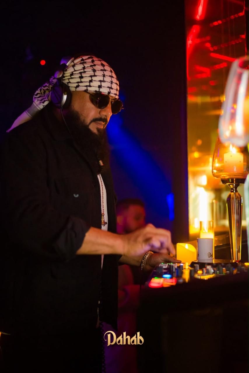 DJ com keffiyeh tocando entre velas